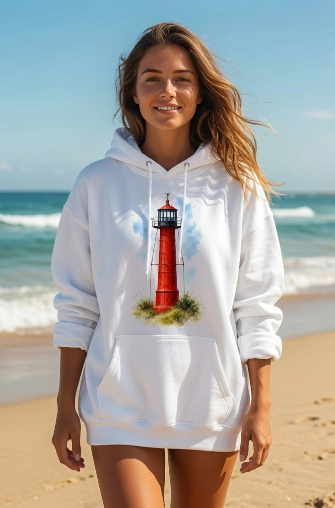 Woman wearing a white hoodie with a lighthouse design on a beach